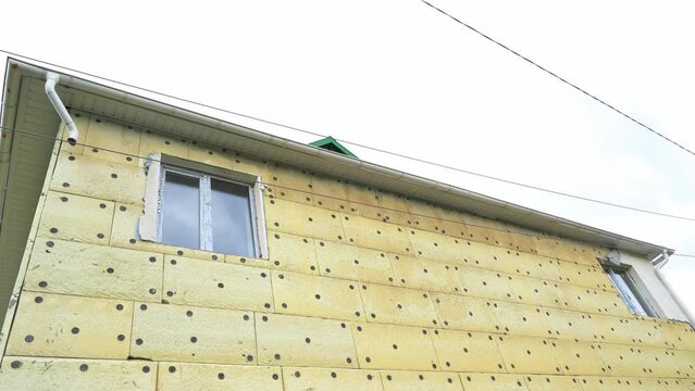 Exterior repair work on the building, insulation and cladding of the facade of the house. Insulation of a residential building. High quality 4k footage