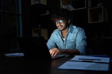 Smiling young curly indian latin ethnic business man or student wearing glasses remote working...