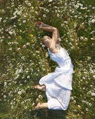 Woman laying in chamomile field