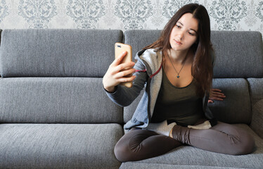 A woman is typing a text message on a smartphone, work from home, distant work. Photo of a young woman, communicating with followers using a mobile phone. Quarantined free time, copy space, banner