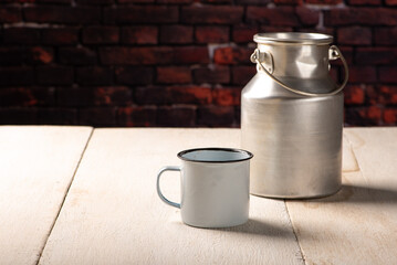 Milk jug and mug on a white wooden table, dark background, selective focus.