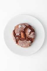Cookies with almonds on a white plate. Isolated object. Photo on a white background. He was lying face down.Top view.Space for copying.Vertical photo.