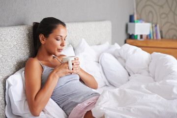 Theres nothing like a cup of coffee in the morning. Attractive young woman blowing the hot steam...