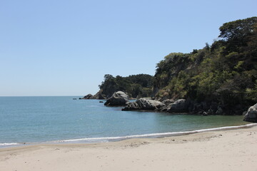 Fototapeta na wymiar 岩場と砂浜がある海岸風景