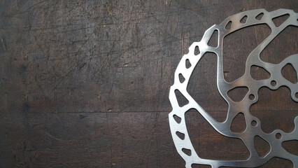 photo - bike brake disc - bicycle parts close up on a dark wood background