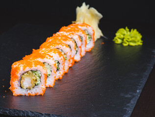 Traditional delicious fresh sushi roll set on a black background with reflection. Sushi roll with rice, cream chees, red fish, salmon. Sushi menu. Japanese kitchen, restaurant. Seafood, asian food