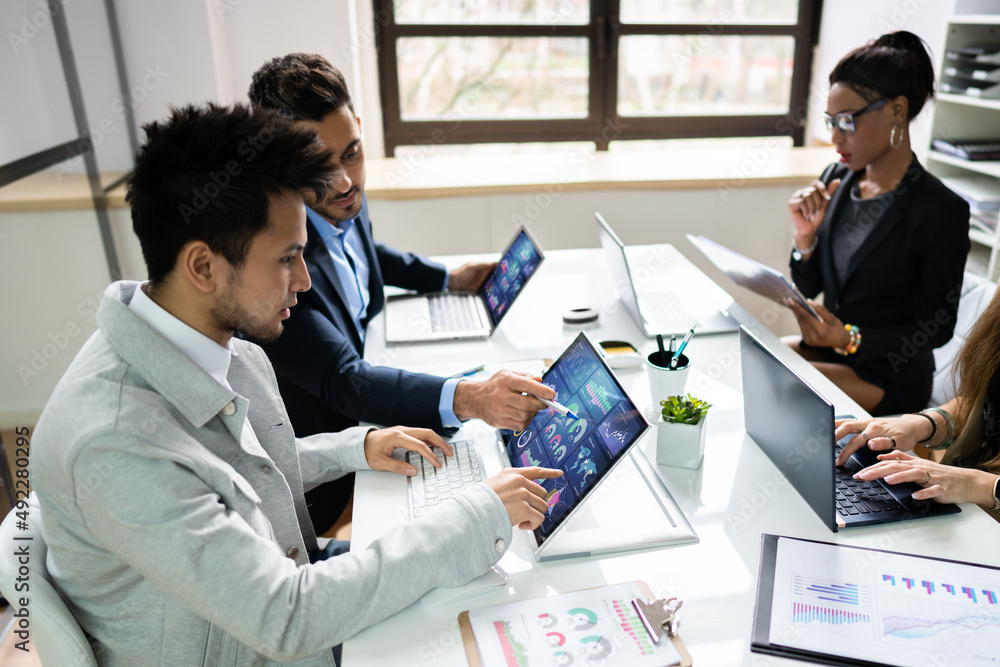 Poster Side View Of Businesspeople Examining Graph On Computer