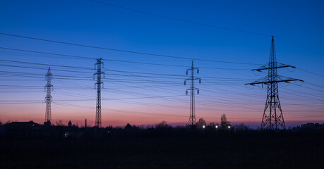 power line pylons after sunset