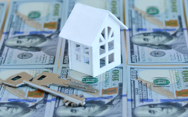 Home expenses or investing concept. Rising house prices, rising mortgage rates.The house stands on...