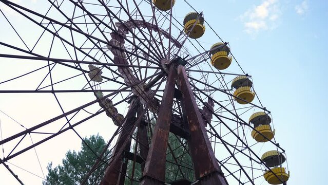 The abandoned ferris wheel in Pripyat from below. Metal rusty structures of the Soviet attraction. High quality 4k footage