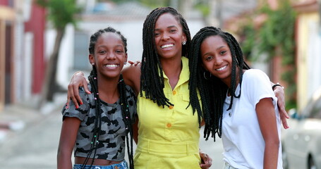 Loving mother and teen daughters embrace. MIxed race teenage girls hugging mom
