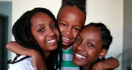 Tuinposter Little brother and steen sisters embrace. Black African ethnicity children © Marco