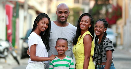 Happy African family portrait standing for photo outside. Cheerful black parents and children
