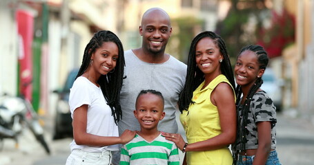 Happy African family portrait standing for photo outside. Cheerful black parents and children