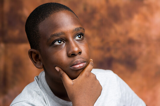 Black African Teenage Boy Looking Up In A Thinking Pose