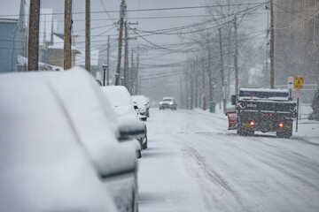 Snow storm plow, small USA town road covered in snow, during snow storm, cars traffic, bad weather...