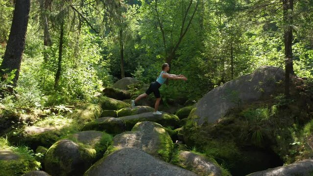 A girl practices balance and yoga in the forest