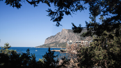 The coast of the Black Sea against the backdrop of mountains in the Crimea, a clear sunny summer...