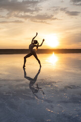 Female ballet dancer is posing in lagoon on low sun background - 492285274