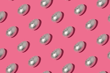 Pattern made of silver eggs on pastel pink background. Minimal Easter or food concept.