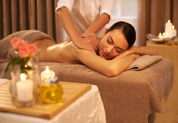 Fototapeta na wymiar Indulging her senses at the spa. A beautiful young woman enjoying a massage at the spa.