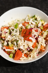 Raw salad in a white bowl, chineese cabbage, tomatoes, pepper, cucumber, healthy diet, vegan, vegetarian