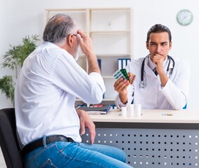 Obraz premium Old man visiting young male doctor