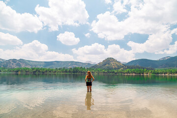 woman model standing on Crater lake in Golcuk Isparta/Turkey. Reflection of blue sky lake, spring 