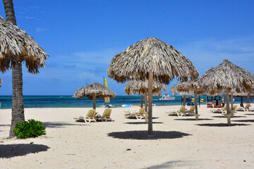 Punta Cana, Dominican Republic - Thatched sun umbrellas on white sand beach, Caribbean coast