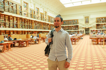 巨大な図書館を歩くラテン系男性