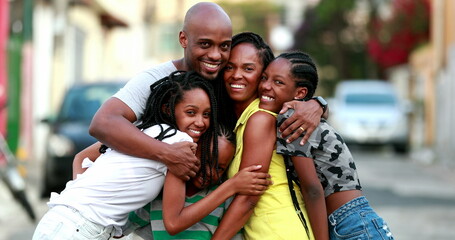 Beautiful black family embrace. Loving father hugging wife and children. African ethnicity