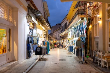 Poster Een smal straatje met cadeau- en souvenirwinkels en cafés in de kleurrijke verlichte wijk Plaka & 39 s nachts in Athene, Griekenland. © Kirk Fisher