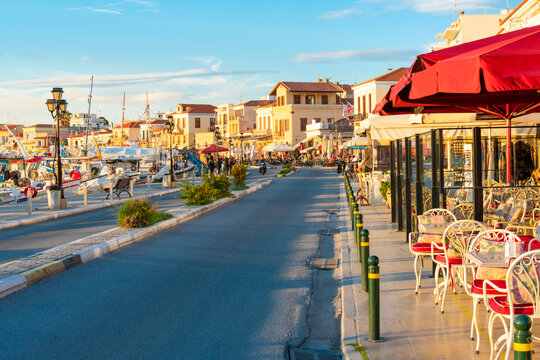 Fototapeta The main street running through the picturesque village of Aegina, on the island of Aegina Greece, with shops and cafes on one side and the marina and port across.