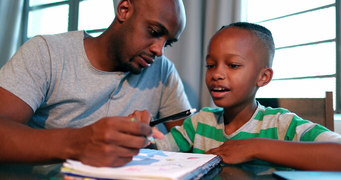 African American father tutoring little boy son