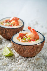 Fresh Tom Yum soup on beach with stones and seashells.
