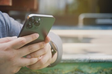 Close up of women's hands holding cell telephone , hipster girl watching video on mobile phone during coffee break