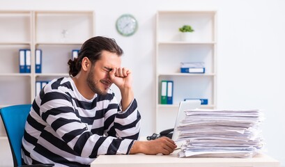 Fototapeta premium Young employee feeling like prisoner at work