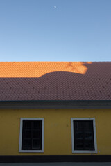 Arquitetura com céu azul e telhado de casa laranja