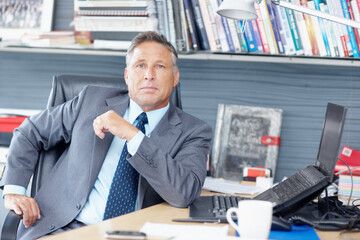 His experience is second to none. Portrait of a formidable business manager sitting at his desk -...