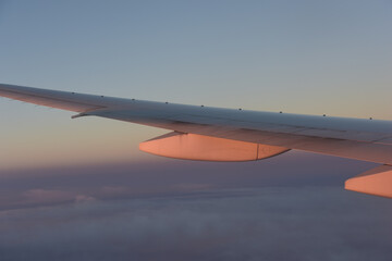 airplane wing with anti-shock bodies reflecting sunset light, feel nostalgia