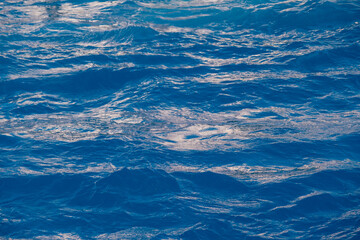Fototapeta na wymiar Vacation near sea, okean. Aqua blue color water surface. Vivid, bright ripple texture. Copy space, top view.
