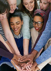 Feeling the team spirit. Cropped shot of a group people putting their hands together in unity.