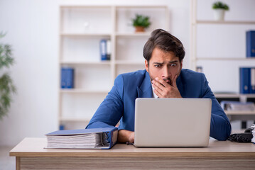 Fototapeta premium Young male employee and too much work in the office