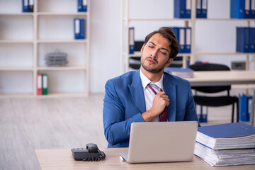 Young male employee and too much work in the office