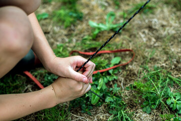 Child pegging down the guy rope of a tent © Corin Walker Bain