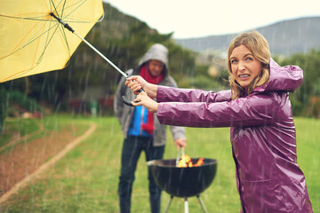 I think its clearing up. Shot of a couple trying to barbecue in the rain.