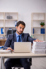 Young male employee and too much work in the office