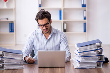 Obraz premium Young male employee unhappy with excessive work in the office