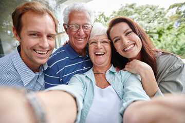 The generation of selfies. Cropped shot of four adults taking a family selfie.