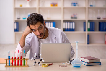 Young male chemist working at the lab